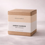 AOVILA Amber Harbor gift ready candle packaging with warm woods home fragrance styling and tiger eye